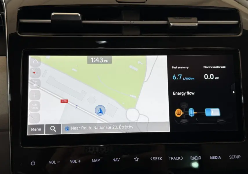 Écran tactile central du Hyundai Tucson gris foncé 2021 affichant navigation 3D et consommation hybride.