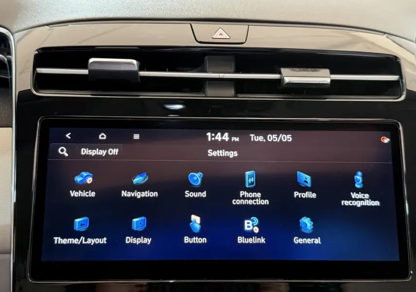 Gros plan sur l'écran tactile central du tableau de bord du Hyundai Tucson gris foncé, affichant le menu des réglages.