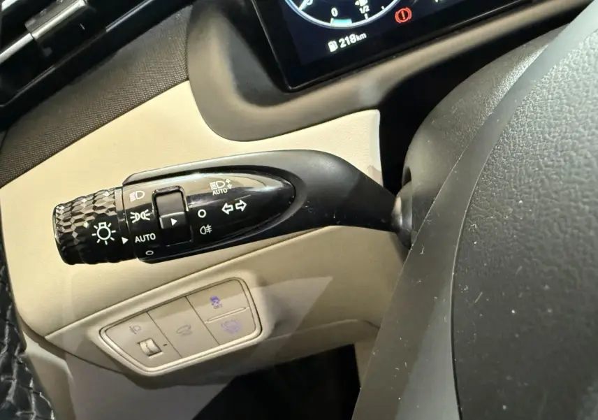 Gros plan sur la commande des phares et clignotants à gauche du volant du Hyundai Tucson gris foncé 1.6 Hybrid 230 Executive 2021.