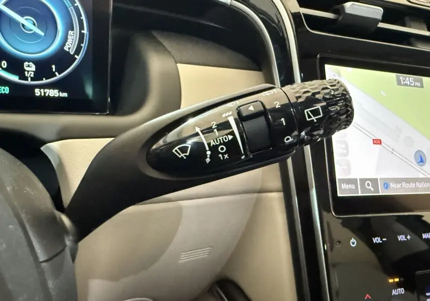 Gros plan sur la commande d’essuie-glace noire et l’écran tactile du tableau de bord du Hyundai Tucson gris foncé 2021.