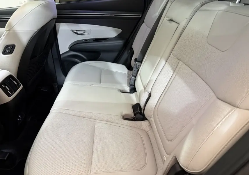 Vue latérale des sièges arrière en cuir beige clair du Hyundai Tucson 1.6 Hybrid 230 Executive, intérieur spacieux et soigné.