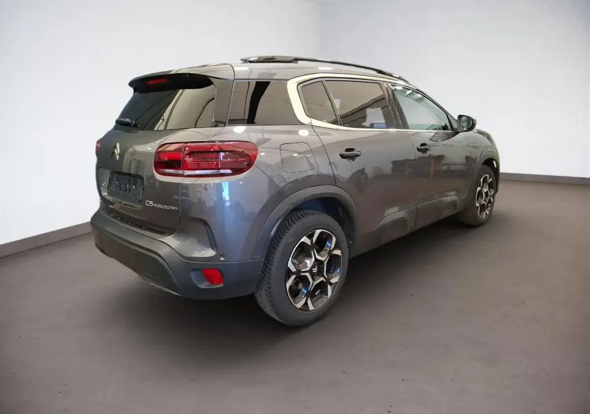 Vue 3/4 arrière droit du Citroën C5 Aircross gris Platinium avec jantes alliage bi-ton et vitres teintées.