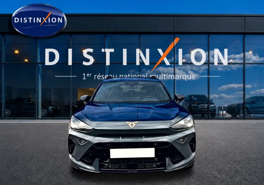 Vue frontale d'une CUPRA Formentor bleu fjord 2026 avec logo distinctif et calandre noire devant un showroom Distinxion.