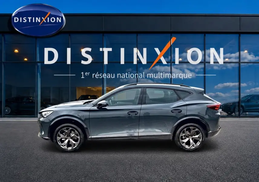 Vue latérale droite d'un CUPRA Formentor 2026 gris métallisé devant une vitrine Distinxion.