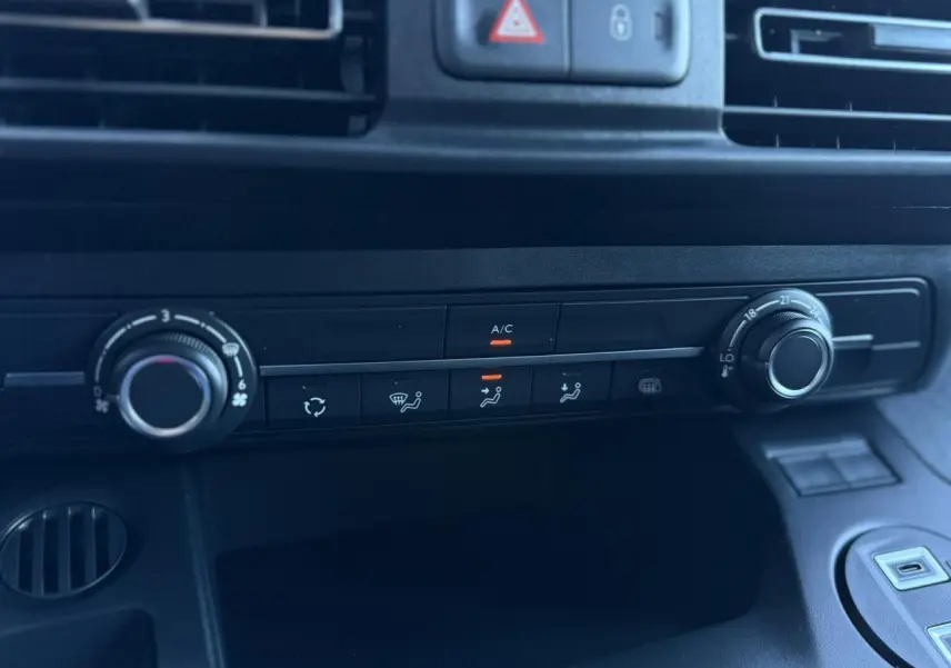 Gros plan sur la console centrale du Peugeot Partner blanc Icy 2026, montrant les commandes de climatisation et ventilation.