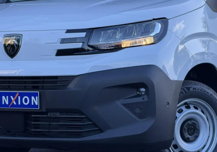 Gros plan sur l'avant droit du Peugeot Partner blanc Icy, avec phares LED et pare-chocs noir mat.