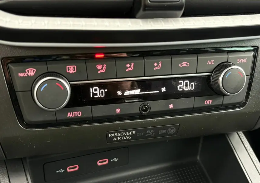 Gros plan sur la console centrale du SEAT Ibiza argent, montrant la climatisation automatique bi-zone avec affichage digital.