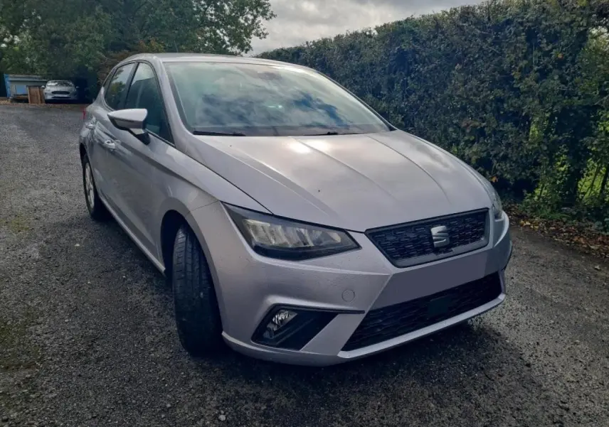 SEAT Ibiza TSI 115 DSG argent urbain vue 3/4 avant gauche sur chemin gravillonné avec haie en arrière-plan