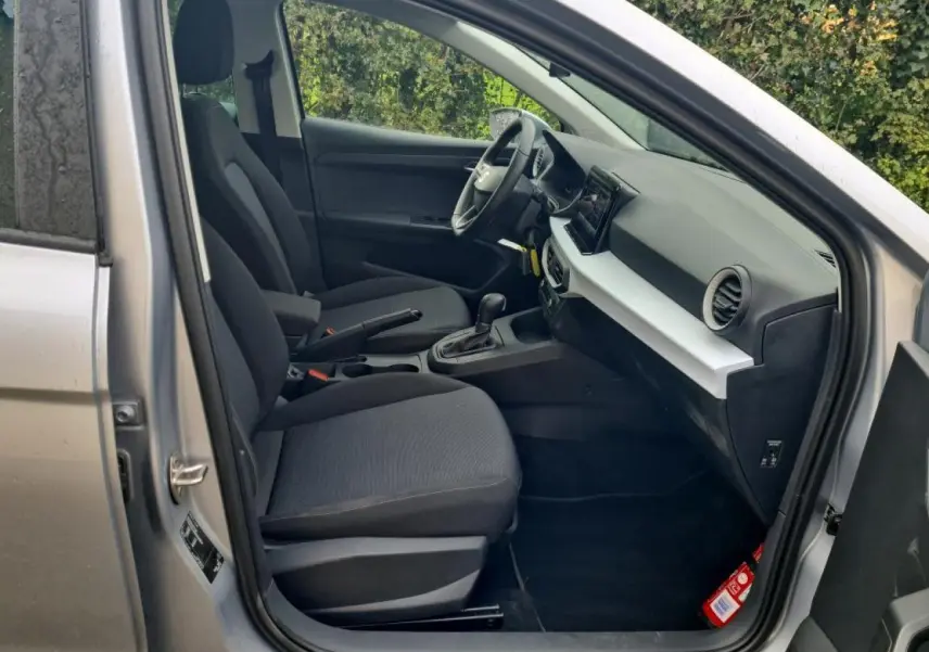 Intérieur côté conducteur de la SEAT Ibiza argent urbain 2024, avec tableau de bord moderne et sièges tissu gris.