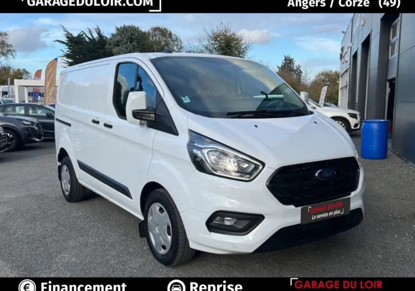 Ford Transit Custom Fourgon blanc vu en 3/4 avant droit, avec calandre noire et feux LED visibles.