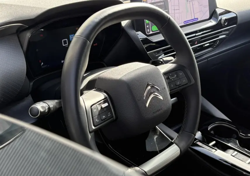 Vue rapprochée du volant cuir noir et du tableau de bord digital du Citroën C5 X 2024 avec écran tactile 12 pouces.
