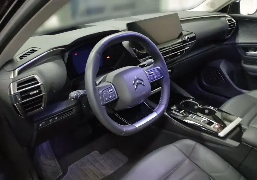 Vue intérieure côté conducteur du Citroën C5 X noir Perla, avec volant cuir et écran tactile central large.