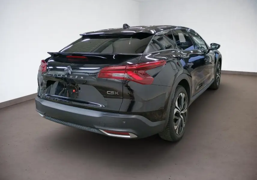 Vue 3/4 arrière droite d'une Citroën C5 X noire Perla avec feux arrière LED 3D et jantes alliage 19 pouces.
