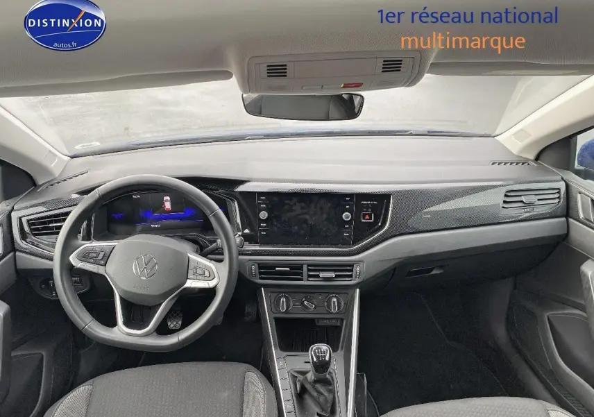 Vue intérieure avant du tableau de bord et volant cuir multifonction de la Volkswagen Polo bleu récif 2025 avec boîte manuelle.