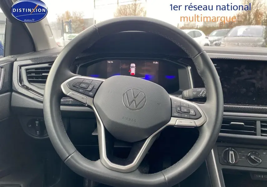 Vue centrée sur le volant cuir multifonction d'une Volkswagen Polo 2025, intérieur noir avec tableau de bord digital.