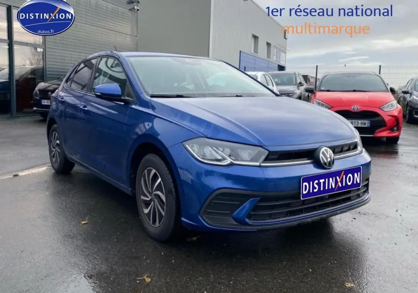 Volkswagen Polo 1.0 TSI bleu récif vue 3/4 avant droit sur parking avec calandre chromée et jantes alliage.