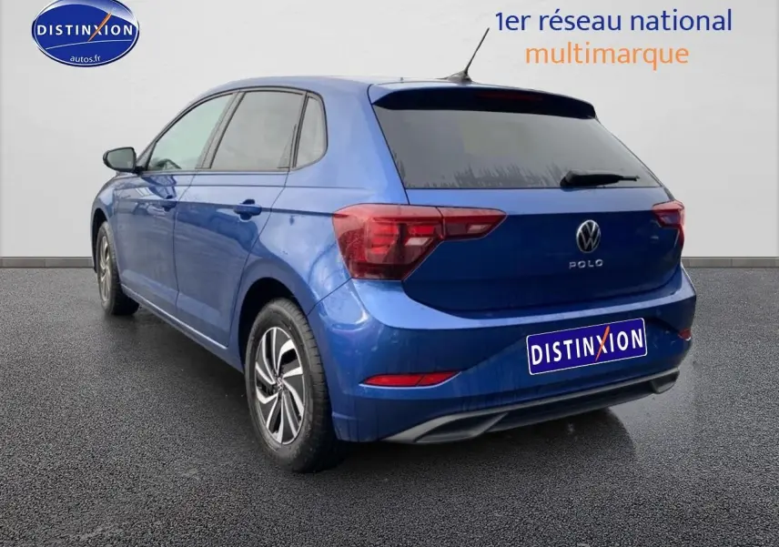 Vue 3/4 arrière gauche d'une Volkswagen Polo 1.0 TSI 95 VW Edition bleu récif avec jantes alliage et vitres surteintées.