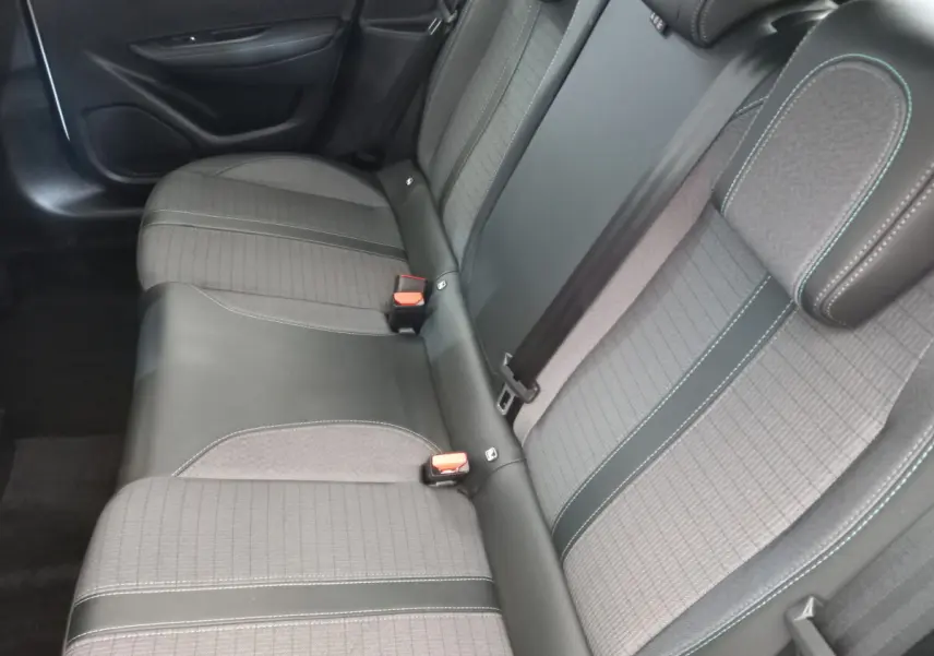 Vue intérieure de la banquette arrière grise et noire de la Peugeot 208 PureTech 100 S&S Allure 2021, avec ceintures visibles.