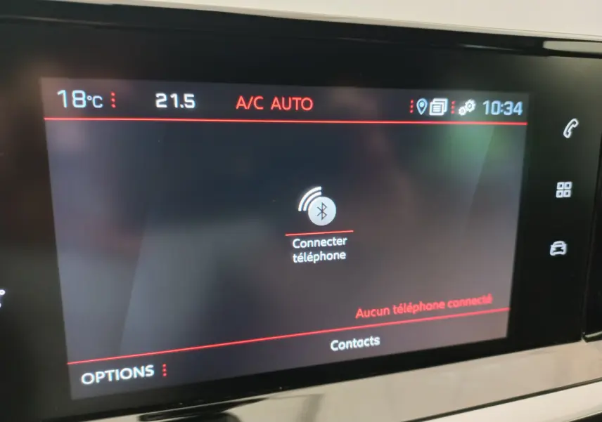 Écran tactile central de la Peugeot 208 PureTech blanc, affichant la connexion Bluetooth pour téléphone.