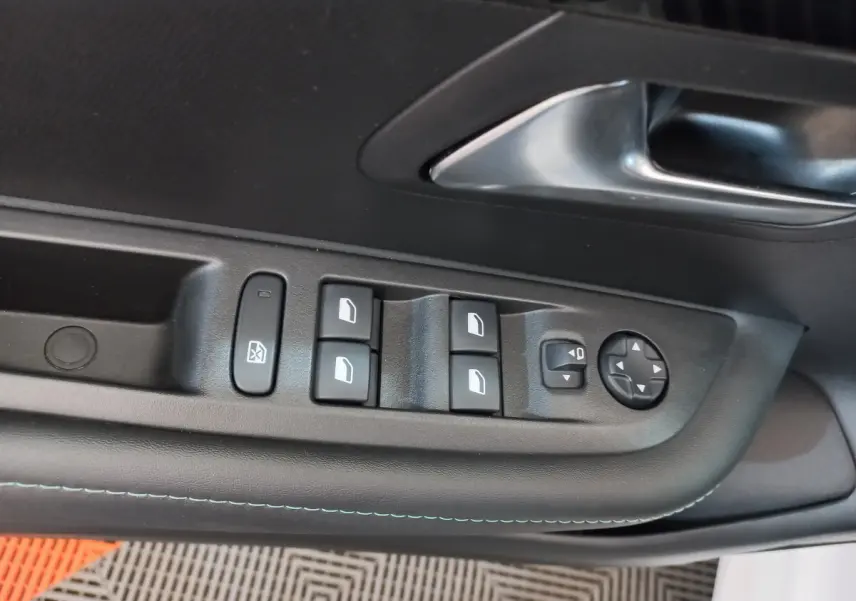 Détail des commandes des vitres et rétroviseurs sur la porte côté conducteur d’une Peugeot 208 blanche PureTech 100 S&S Allure 2021.