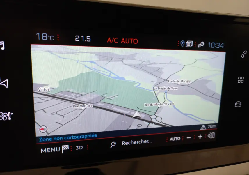 Écran tactile intérieur du tableau de bord du Peugeot 208 blanc, affichant la navigation GPS en mode 2D.