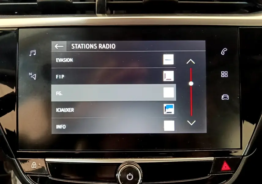 Écran tactile central de la console de l’Opel Corsa 2023 affichant les stations radio, interface noire brillante.