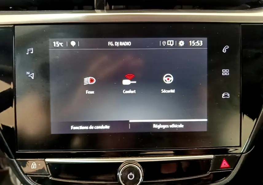 Écran tactile central de la console de l’Opel Corsa blanc, affichant les réglages feux, confort et sécurité.