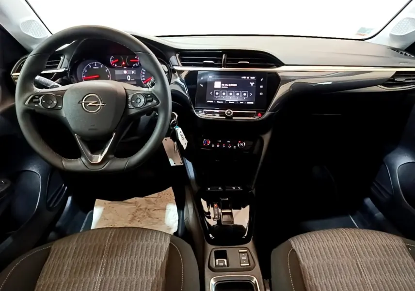 Vue intérieure avant de l’Opel Corsa 2023, tableau de bord noir avec écran tactile central et volant multifonctions cuir.