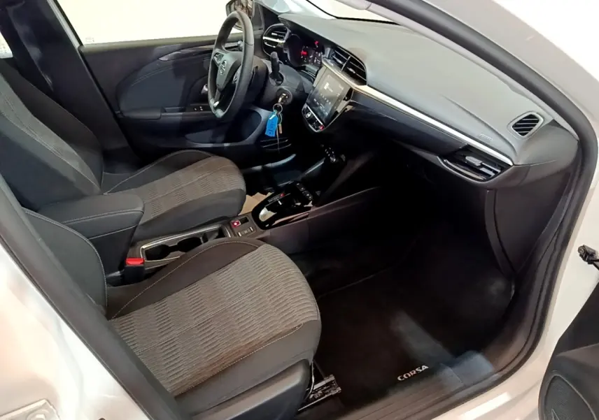 Intérieur avant droit de l’Opel Corsa blanc 2023, tableau de bord moderne avec écran tactile et sièges tissu gris.