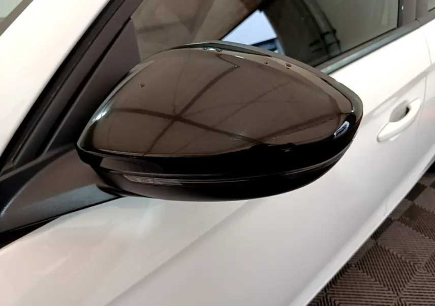 Rétroviseur extérieur noir côté gauche sur Opel Corsa blanche vue rapprochée du côté conducteur.