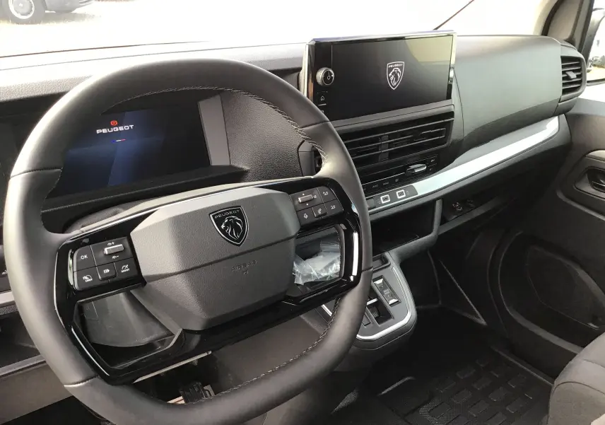 Vue intérieure du poste de conduite du Peugeot Expert Cabine Approfondie noir, avec volant compact et écran tactile central.