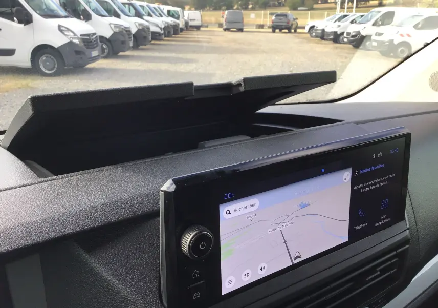 Vue intérieure du tableau de bord du Peugeot Expert XL noir, avec écran tactile de navigation et rangement ouvert au-dessus.
