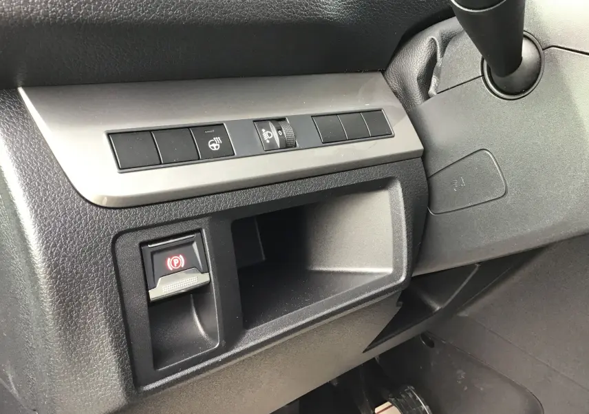 Gros plan sur la console côté gauche du tableau de bord noir du Peugeot Expert Cabine Approfondie avec bouton frein à main électronique.