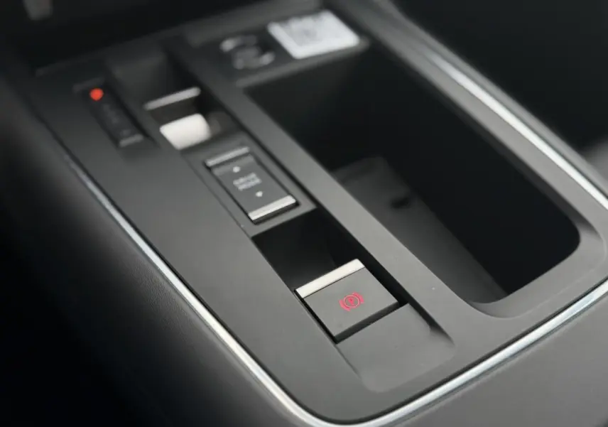 Gros plan sur la console centrale noire du Citroën C5 Aircross 2025 avec frein de stationnement électrique et commandes.