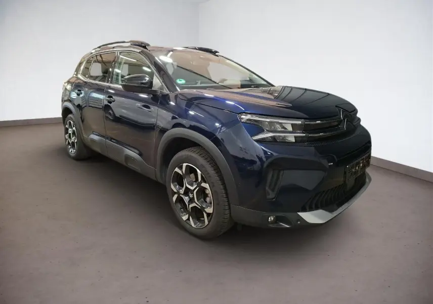 Citroën C5 Aircross Bleu Eclipse en 3/4 avant droit, avec jantes alliage bi-ton et barres de toit noires.