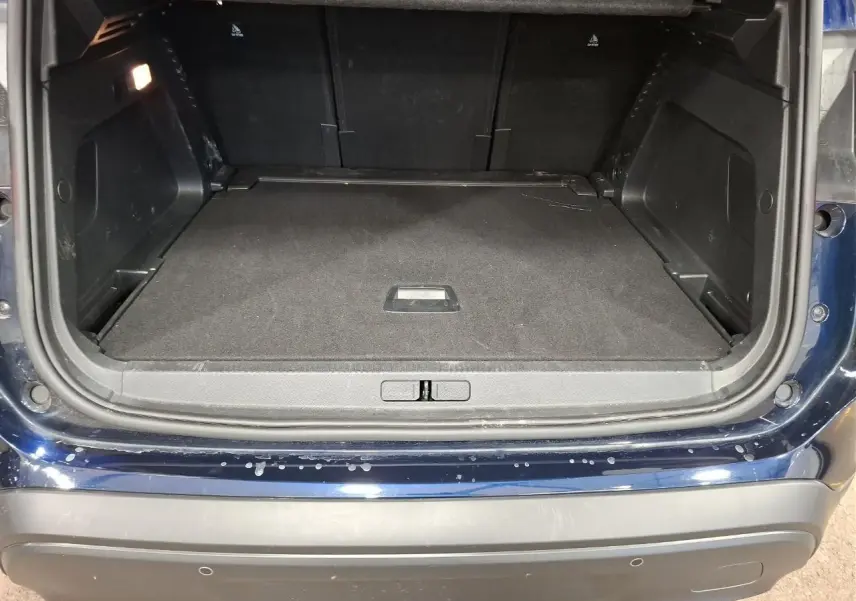 Coffre ouvert vu de l'arrière d'un Citroën C5 Aircross Bleu Eclipse avec plancher plat et garnitures noires.