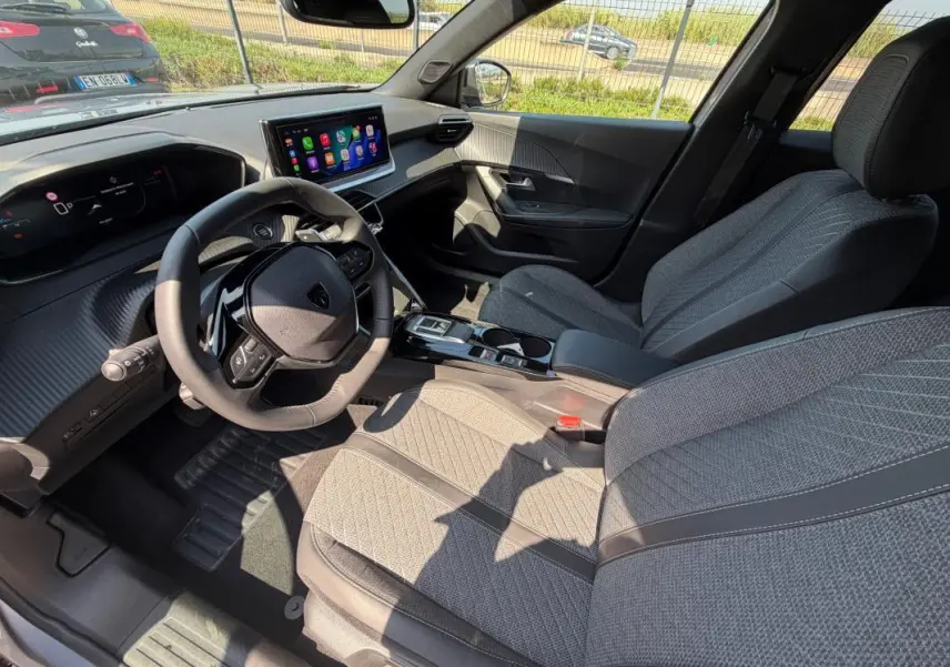 Intérieur du Peugeot 2008 Hybrid 145 e-DCS6 Allure 2025, vue côté conducteur, sièges gris et tableau de bord numérique.