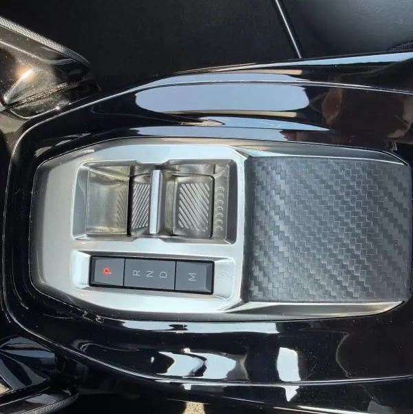 Vue rapprochée de la console centrale noire du Peugeot 2008 Hybrid 145 e-DCS6 Allure avec commandes de boîte automatique.