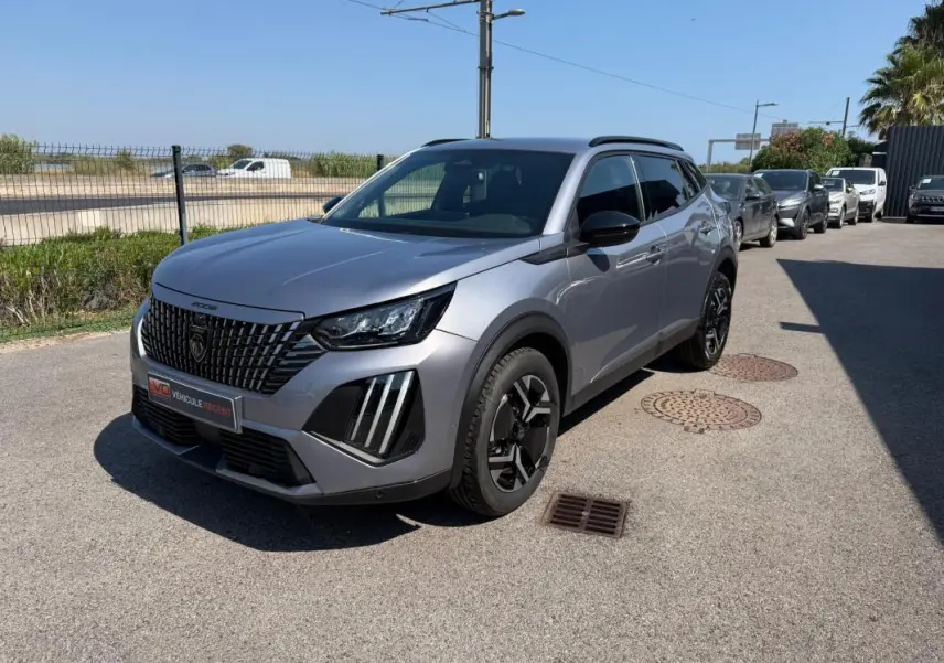 Peugeot 2008 Hybrid 145 e-DCS6 Allure gris vue 3/4 avant droit avec calandre distinctive et jantes noires.