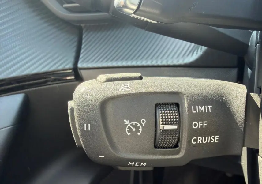 Gros plan sur la commande de régulateur de vitesse du Peugeot 2008 Hybrid 145 e-DCS6 Allure gris, intérieur.