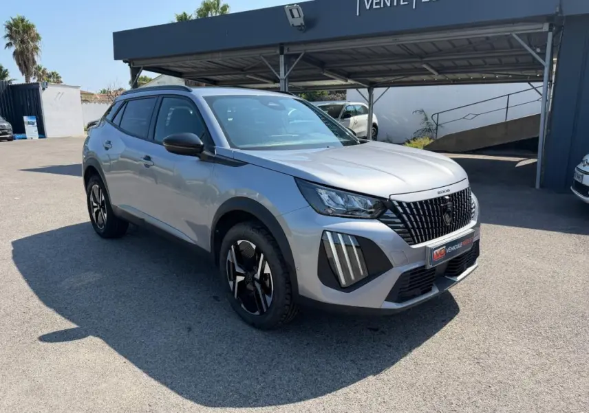 Peugeot 2008 Hybrid 145 gris en 3/4 avant droit, avec calandre noire distinctive et jantes modernes.