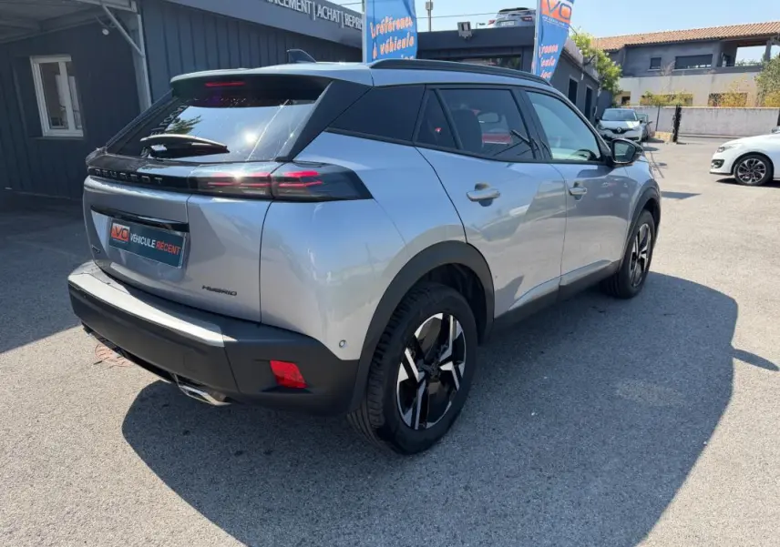 Vue 3/4 arrière droite du Peugeot 2008 Hybrid 145 gris avec feux arrière LED et jantes noires distinctives.