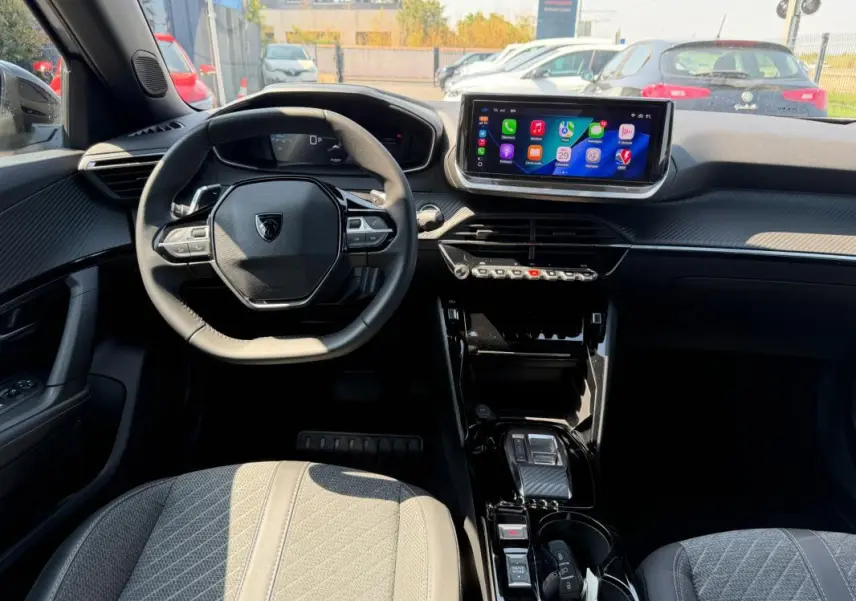 Vue intérieure de face du Peugeot 2008 Hybrid 145 e-DCS6 Allure 2025, avec tableau de bord noir et écran tactile central.