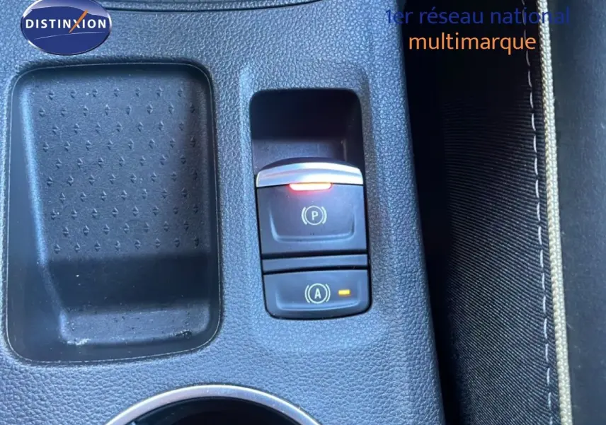 Gros plan sur la console centrale du Renault Symbioz 2025, avec boutons de frein à main et arrêt auto en plastique noir.