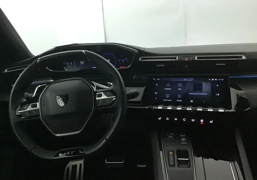 Intérieur du Peugeot 508 SW 2024, vue du poste de conduite avec volant GT et écran tactile central allumé.