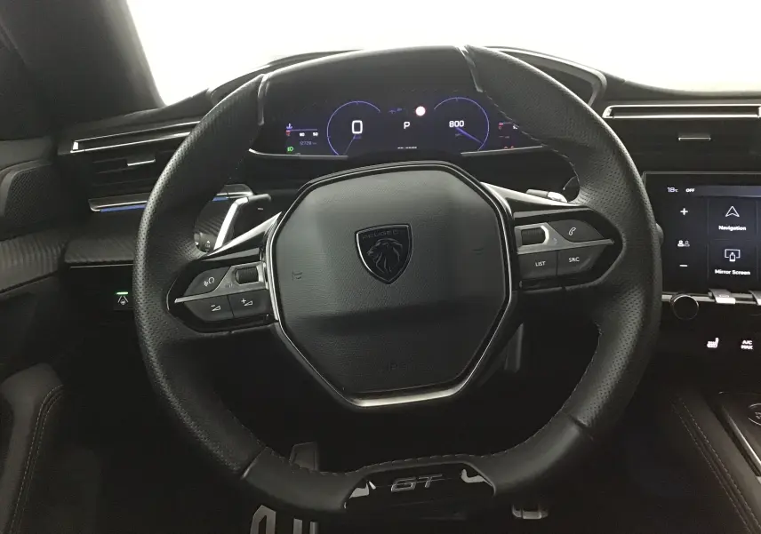 Vue rapprochée du volant cuir noir GT avec commandes intégrées du tableau de bord numérique du Peugeot 508 SW 2024.