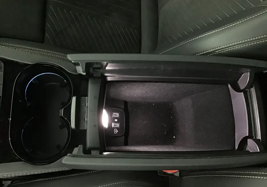 Vue plongeante sur la console centrale ouverte du Peugeot 508 SW gris Artense, montrant un rangement avec ports USB éclairés.