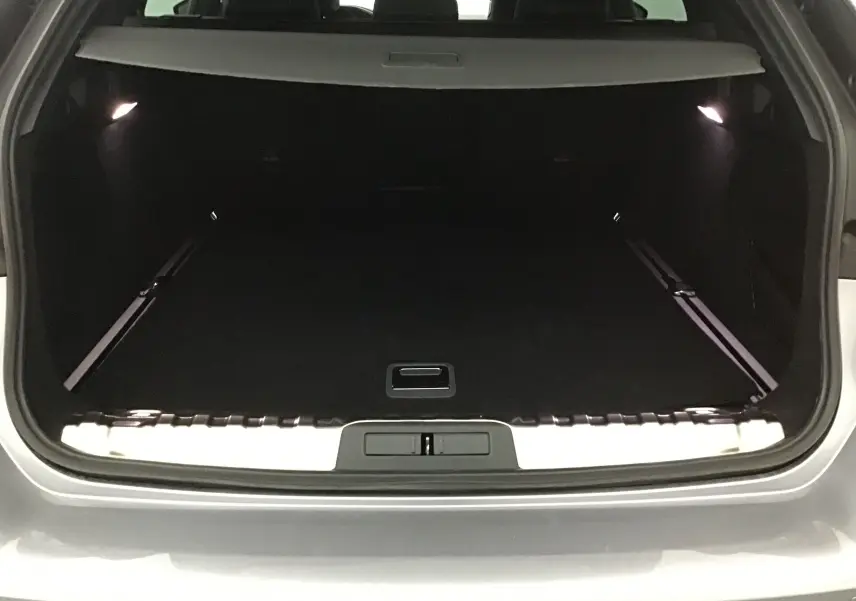 Coffre ouvert d'une Peugeot 508 SW gris Artense, vue arrière montrant l'espace de chargement spacieux et éclairé.