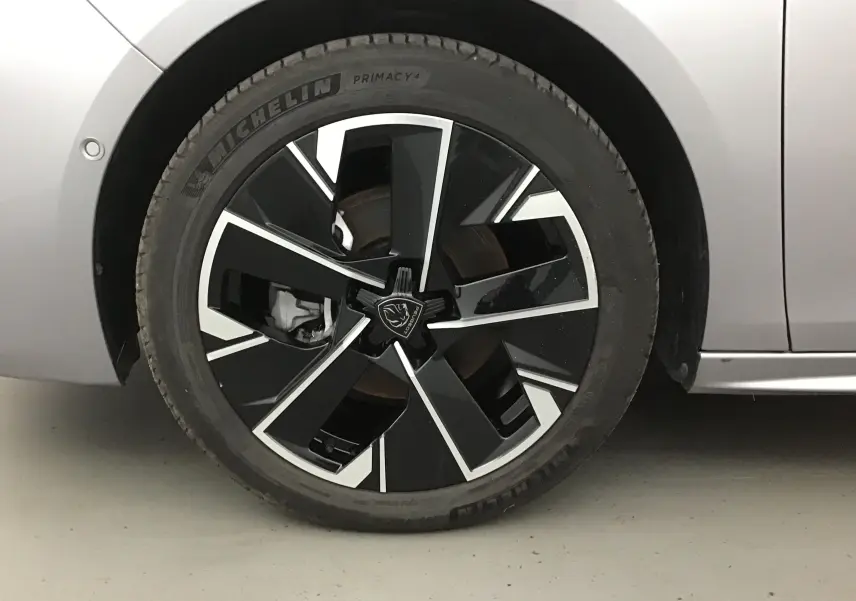 Gros plan sur la roue avant gauche de la Peugeot 508 SW gris Artense avec jante noire et argentée au design moderne.