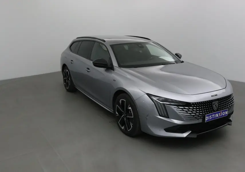 Peugeot 508 SW gris Artense en 3/4 avant droit, avec calandre distinctive et jantes noires stylées.